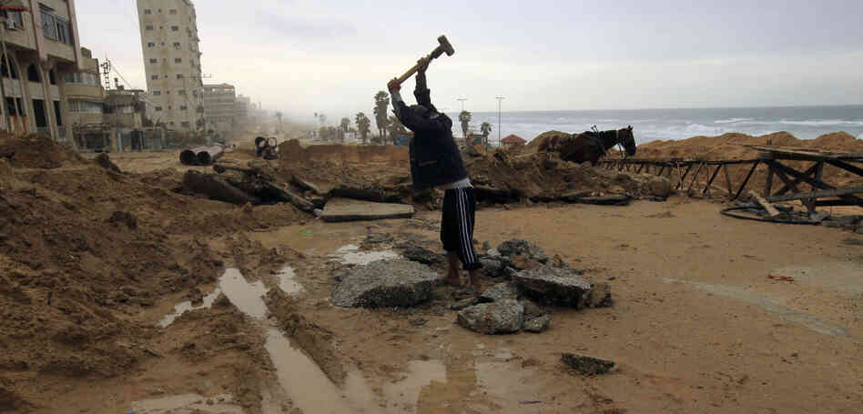 A Palestinian youth breaks up stones for construction in Gaza City. Despite restrictions on imports including building material, the area is going through a construction boom.