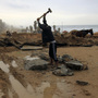 A Palestinian youth breaks up stones for construction in Gaza City. Despite restrictions on imports including building material, the area is going through a construction boom.