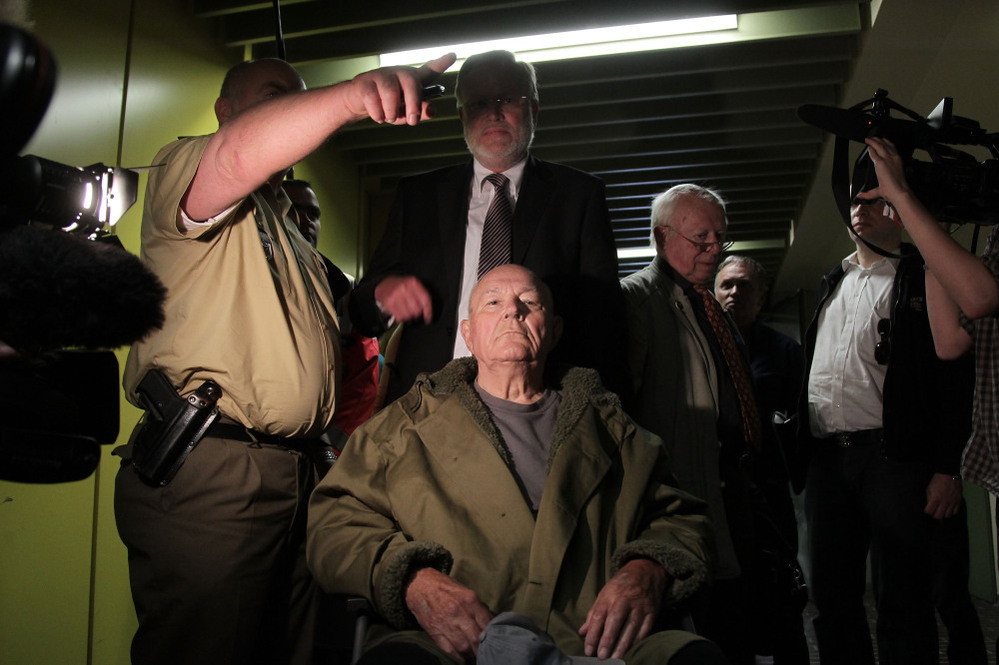  John Demjanjuk emerges from the courtroom with his lawyers after a judge sentenced him to five years in prison for charges related to 28,060 counts of accessory to murder in May 2011 in Munich, Germany. 