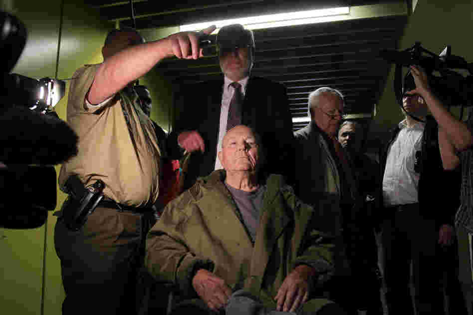  John Demjanjuk emerges from the courtroom with his lawyers after a judge sentenced him to five years in prison for charges related to 28,060 counts of accessory to murder in May 2011 in Munich, Germany. 