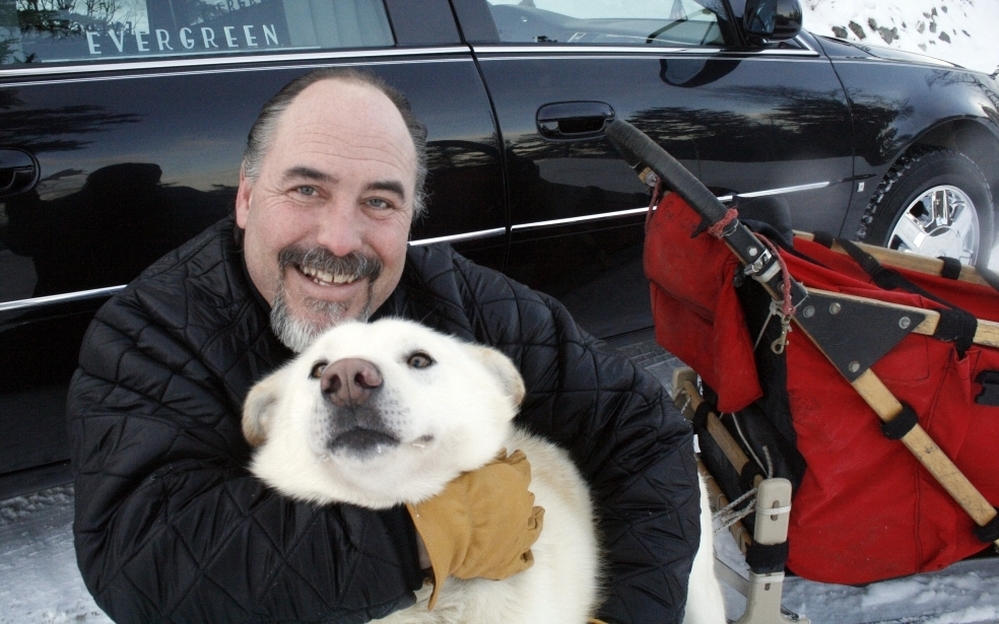 Iditarod Trail Sled Dog Race rookie Scott Janssen, known as the "Mushing Mortician," of Anchorage, Alaska, poses for a photo with one of his pet dogs. 