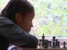 Rochelle, one of the kids in Brooklyn Castle, examines a chess board.