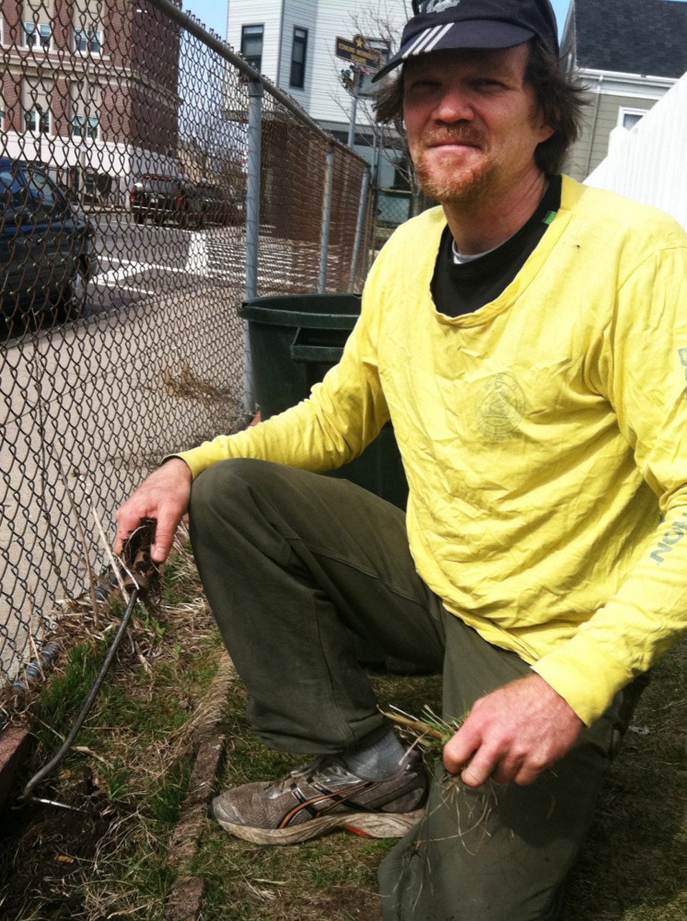 Handyman Peter Brook, 51, pulls weeds outside his church in Boston. Before 2006, Brook says, he couldn't afford health care.