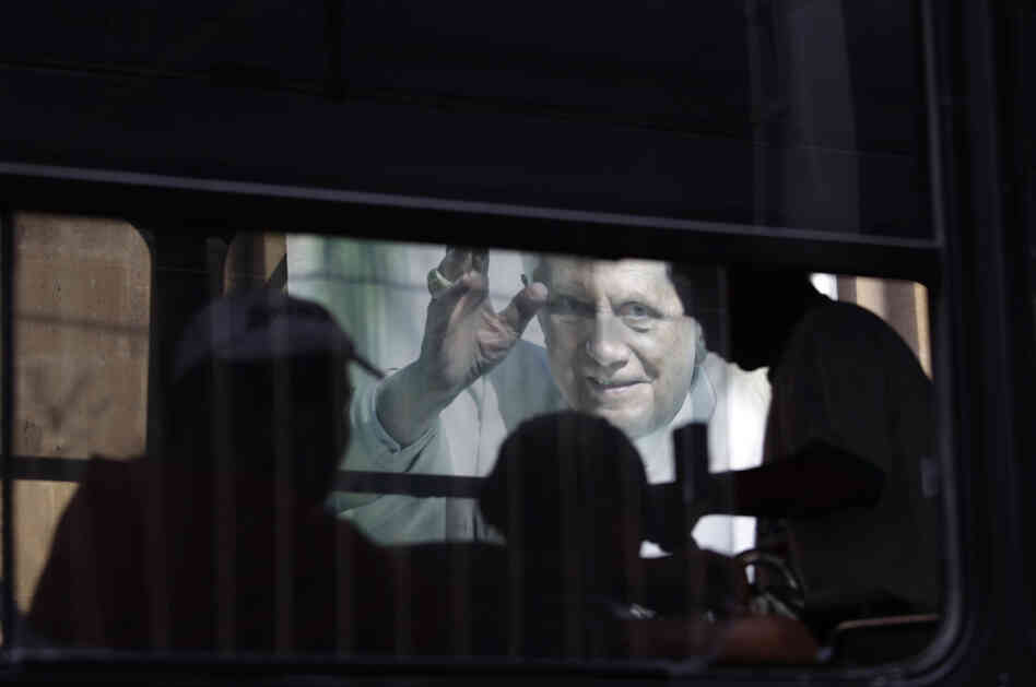 In this Feb. 29, 2012 photo, people riding on a bus pass a banner of Pope Benedict XVI on the wall of a church in Leon, Mexico.
