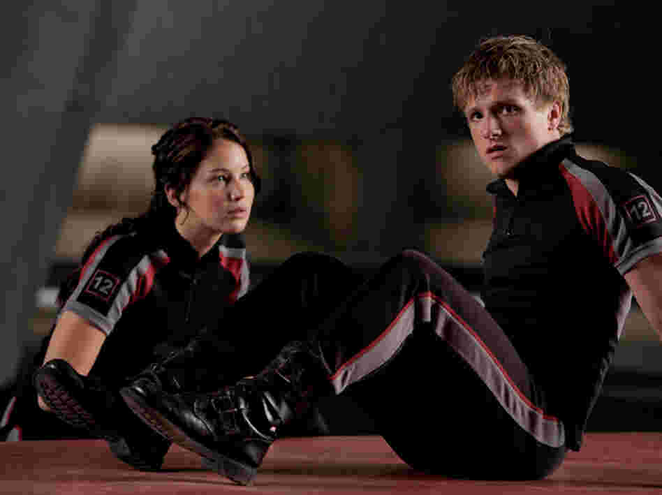 In The Hunger Games, Katniss (Jennifer Lawrence) and Peeta (Josh Hutcherson) train to compete against other teenagers in a fight to the death that all citizens of a ruined North American dystopia must watch. In The Hunger Games, Katniss (Jennifer Lawrence) and Peeta (Josh Hutcherson) train to compete against other teenagers in a fight to the death that all citizens of a ruined North American dystopia must watch.