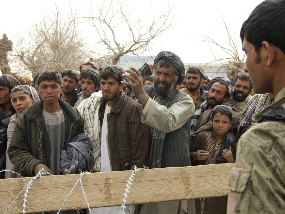 Afghans gather outside a military base in the Panjwai district in Afghanistan on March 11, after 16 civilians were killed in a massacre allegedly carried out by a U.S. soldier.  