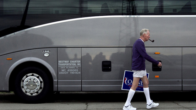 Jim Wilson of Buckingham, Va., who supports Republican presidential candidate Mitt Romney, walks past a bus during a Romney campaign stop Monday in Springfield, Ill.