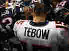 Tim Tebow of the Denver Broncos kneels and prays with teammates and members of the New England Patriots after the Patriots won 45-10 during their AFC Divisional Playoff Game at Gillette Stadium on January 14, 2012. Tim Tebow of the Denver Broncos kneels and prays with teammates and members of the New England Patriots after the Patriots won 45-10 during their AFC Divisional Playoff Game at Gillette Stadium on January 14, 2012.
