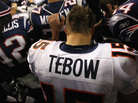 Tim Tebow of the Denver Broncos kneels and prays with teammates and members of the New England Patriots after the Patriots won 45-10 during their AFC Divisional Playoff Game at Gillette Stadium on January 14, 2012. Tim Tebow of the Denver Broncos kneels and prays with teammates and members of the New England Patriots after the Patriots won 45-10 during their AFC Divisional Playoff Game at Gillette Stadium on January 14, 2012.