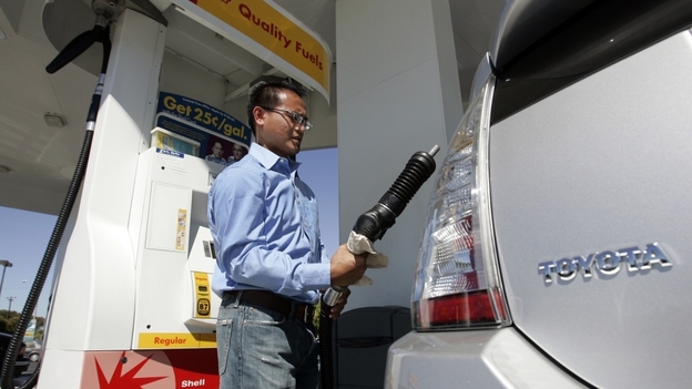 A driver pumps gas into his Toyota Prius hybrid at a gas station in Sunnyvale, Calif., in 2007.