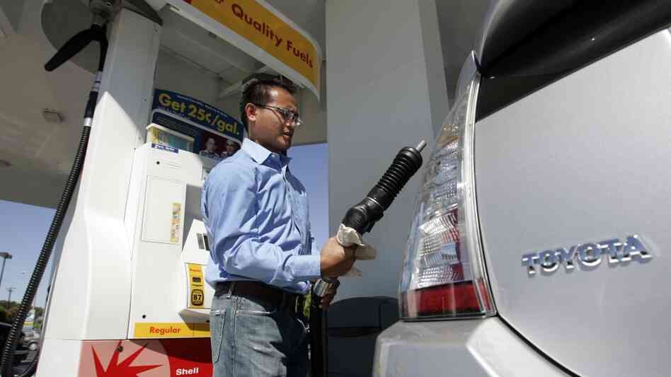 A driver pumps gas into his Toyota Prius hybrid at a gas station in Sunnyvale, Calif., in 2007.