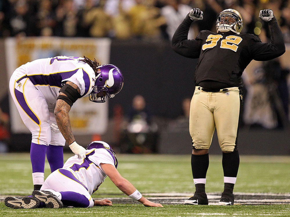 Phil Loadholt of the Minnesota Vikings checks on teammate Brett Favre after he was hit by Remi Ayodele of the New Orleans Saints during the NFC Championship Game  January 24, 2010.
