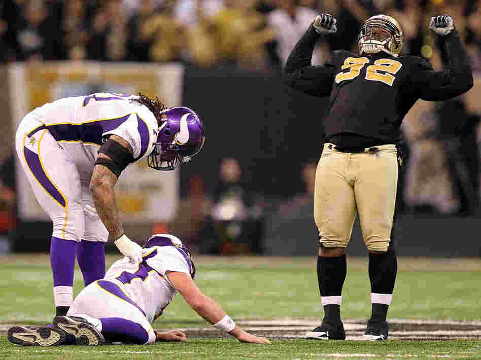 Phil Loadholt of the Minnesota Vikings checks on teammate Brett Favre after he was hit by Remi Ayodele of the New Orleans Saints during the NFC Championship Game  January 24, 2010.