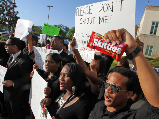 Brandon Northington (right) a FAMU law student chants, "Do I look suspicious?" while holding a bag of Skittles during a rally Monday at the Seminole County Courthouse in Sanford, Fla. Trayvon Martin was holding the candy when he was shot and killed.