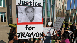 Demonstrators rally at the Seminole County Courthouse on Monday, demanding the arrest of a neighborhood watch captain who shot Martin, an unarmed black teen, last month.
