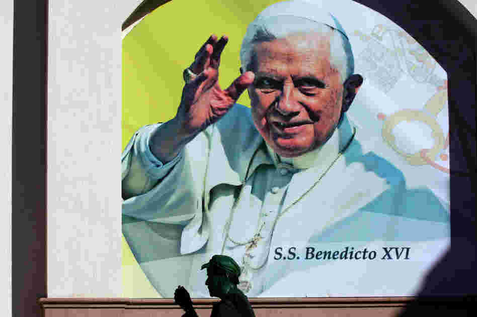 Pope Benedict XVI is expected to speak out against drug violence during his visit to Mexico, which begins Friday. Here, an actor is shown in front of a poster announcing the pope's visit Wednesday in the Mexican city of Leon, Guanajuato state.