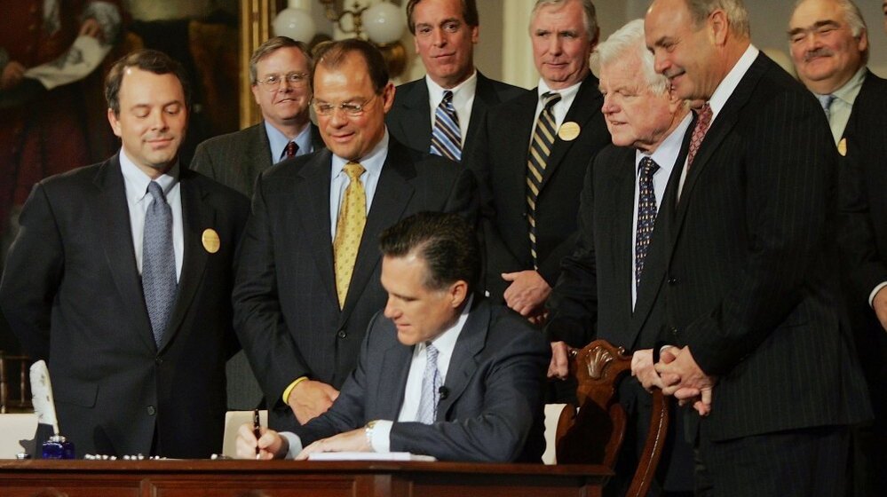 Massachusetts Gov. Mitt Romney signs into law a new health care reform bill during an April 12, 2006, ceremony at Faneuil Hall in Boston. The bill made Massachusetts the first state in the country to require that all residents have health insurance and has become a centerpiece of criticisms leveled by Romney's opponents in the 2012 presidential race. 