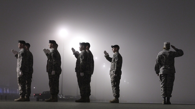 An Army carry team salutes a vehicle containing the remains of an American soldier killed in Afghanistan on March 17, at Dover Air Force Base in Dover, Del.