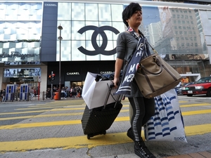A mainland Chinese tourist crosses the street carrying multiple shopping bags in Hong Kong's Tsim Sha Tsui district. Tourists from the mainland spend more money in Hong Kong than tourists from all other countries combined. A mainland Chinese tourist crosses the street carrying multiple shopping bags in Hong Kong's Tsim Sha Tsui district. Tourists from the mainland spend more money in Hong Kong than tourists from all other countries combined.