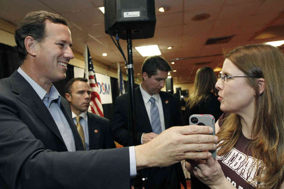 Rick Santorum takes the phone to speak to a supporter's husband, who couldn't attend a Shreveport, La., rally, on Friday.