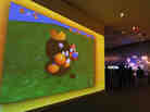 A large video screen shows a scene from Super Mario Bros. at the exhibition "The Art of Video Games."