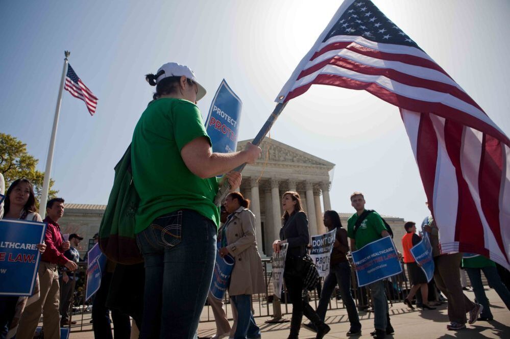 Demonstrators in support of President Obama's health care overhaul march outside the U.S. Supreme Court on Monday. 