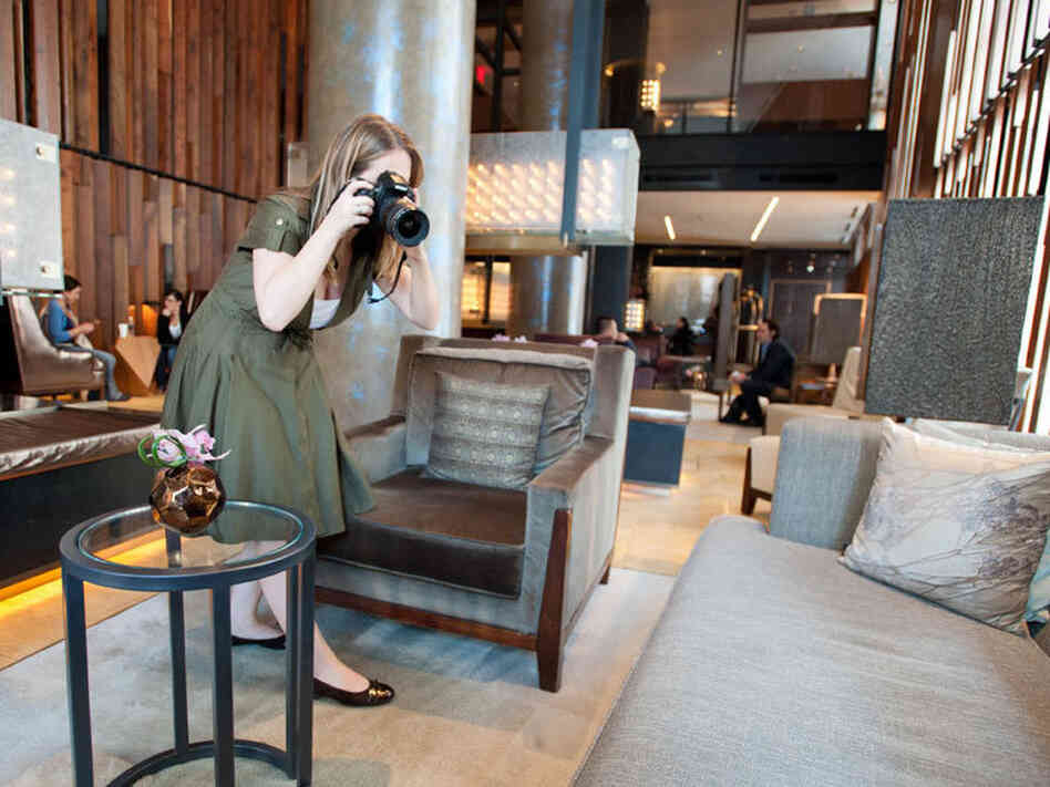 Kelsey Blodget of Oyster.com photographs the lobby of New York's Trump SoHo hotel. The website relies on tech-savvy workers to create online reviews and track hotel bookings.