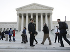 Members of the public line up Monday morning as the Supreme Court begins three days of arguments on the health care overhaul law signed by President Obama in Washington.