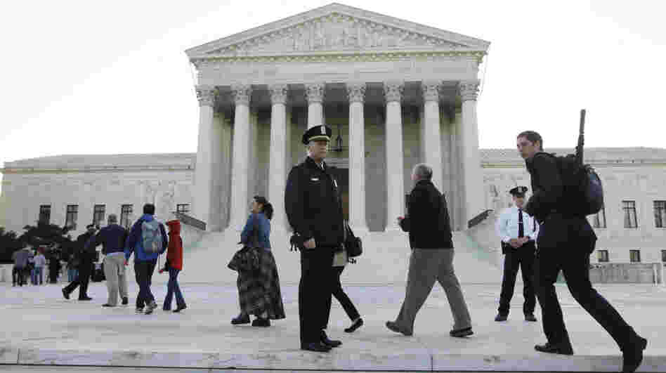 Members of the public line up Monday morning as the Supreme Court begins three days of arguments on the health care overhaul law signed by President Obama in Washington.