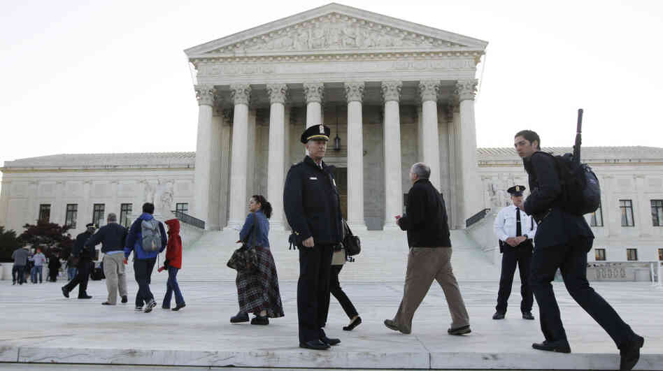 Members of the public line up Monday morning as the Supreme Court begins three days of arguments on the health care overhaul law signed by President Obama in Washington.
