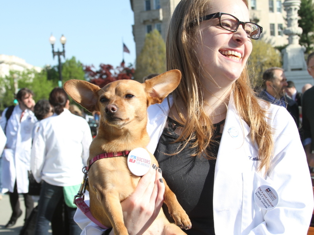Katherine Prather, a first year medical student at Georgetown University, and her dog, Ellie, showed their support for the health care overhaul law at rally outside the Supreme Court Monday.