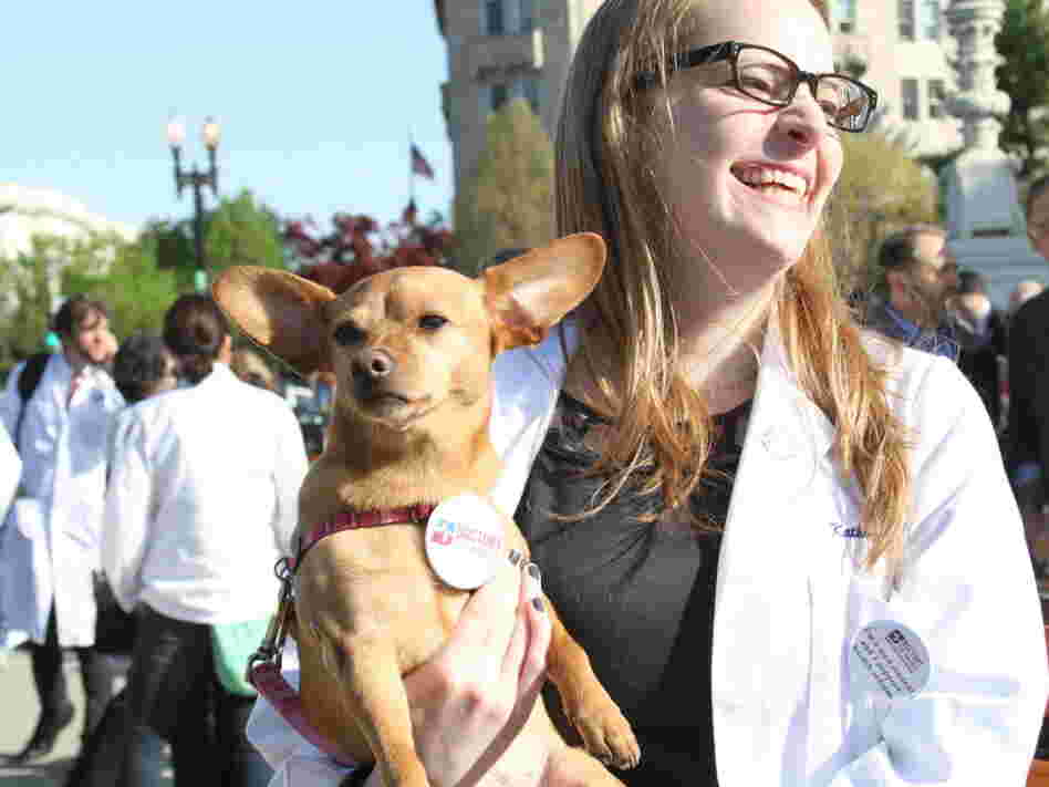 Katherine Prather, a first year medical student at Georgetown University, and her dog, Ellie, showed their support for the health care overhaul law at rally outside the Supreme Court Monday.