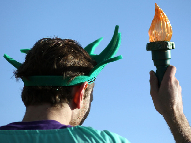 An activist dressed as the Statue of Liberty participates in a protest on the second day of oral arguments over President Obama's health care law on Tuesday.