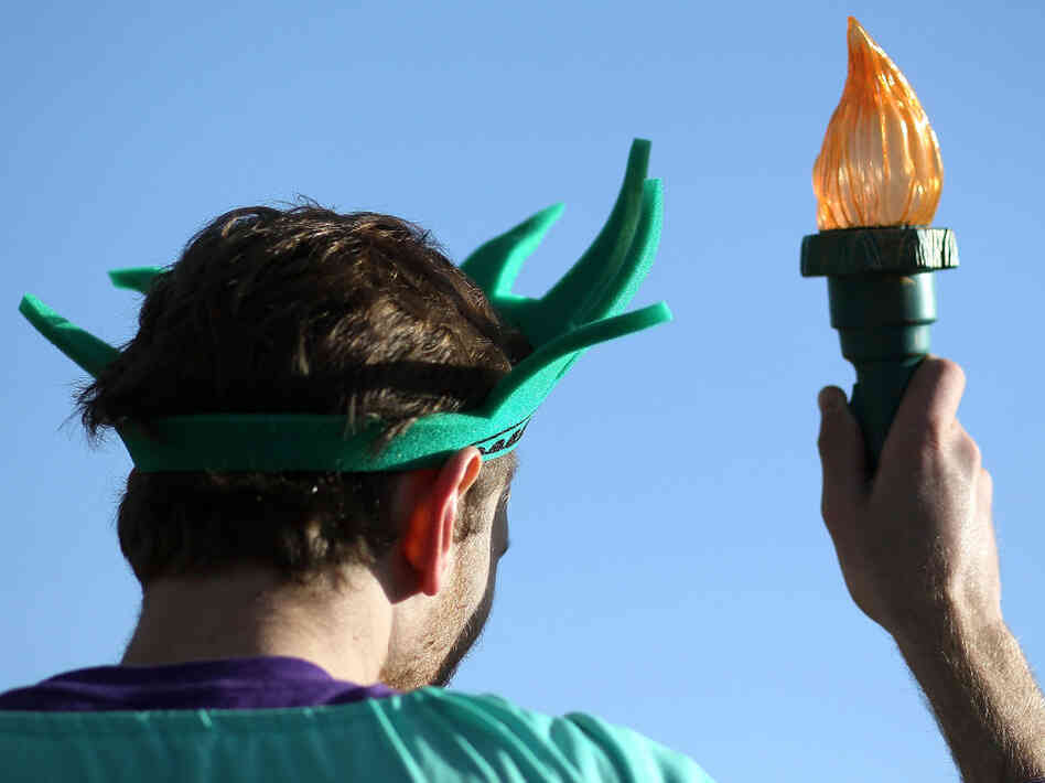 An activist dressed as the Statue of Liberty participates in a protest on the second day of oral arguments over President Obama's health care law on Tuesday.