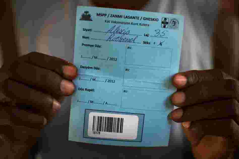 Rice farmer Alexis Rochenel, Fifi's husband, shows his blank cholera vaccination card. People will need two doses of vaccine spread over several weeks. Health workers could have been finished with the first round of vaccinations by now. But they're still waiting for the government to sign off on the project.