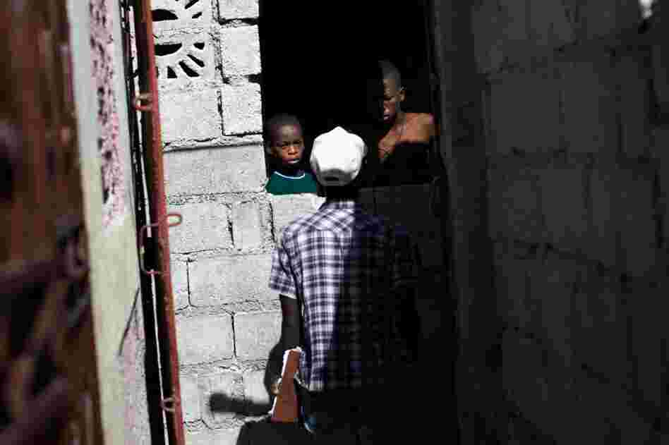 A GHESKIO worker goes door to door in Cite de Dieu. As part of the planned vaccination campaign, an army of health workers has gone out to inform Haitians about cholera and sign them up to get the vaccine.