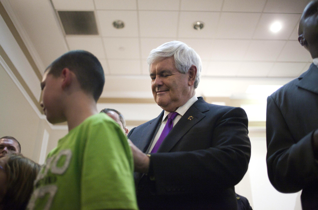 Republican presidential candidate, former House Speaker Newt Gingrich, right, signs a shirt after speaking in Hockessin, Del. on Monday.