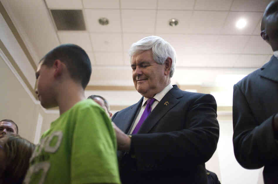 Republican presidential candidate, former House Speaker Newt Gingrich, right, signs a shirt after speaking in Hockessin, Del. on Monday.