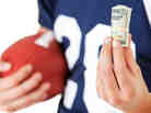 Football player holding football and cash Football player holding football and cash