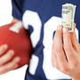 Football player holding football and cash Football player holding football and cash
