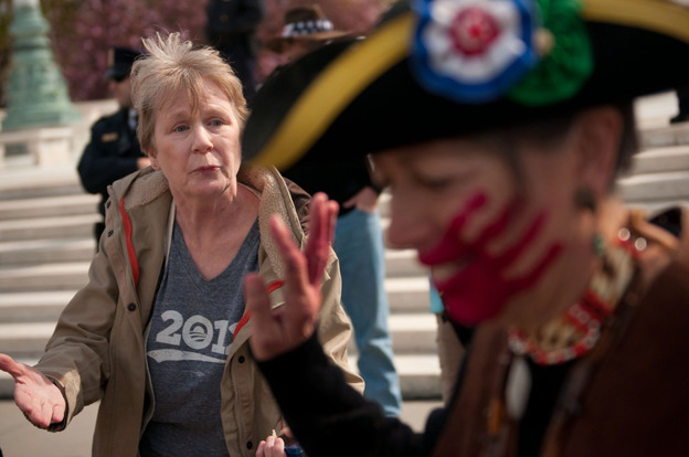 Holly Harness (left), a supporter of the health care law, argues with Susan Clark, an opponent of the law, outside the Supreme Court on Wednesday.