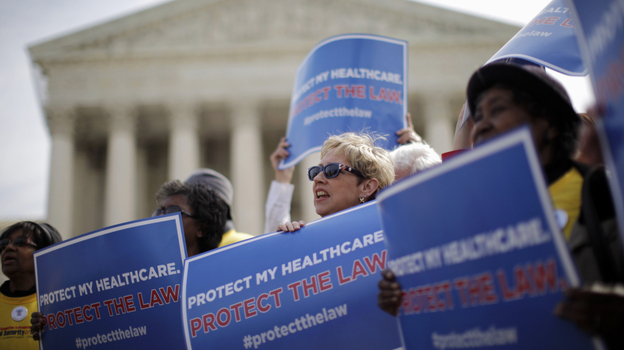 Supporters of the health care law rally in front of the Supreme Court Wednesday, the final day of arguments over its constitutionality.