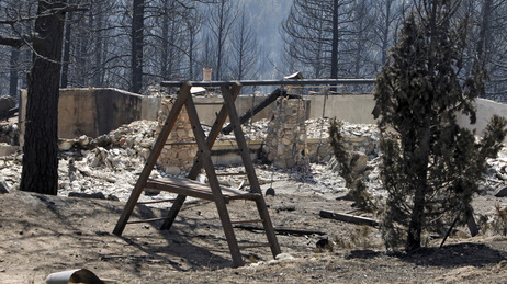 The ruins of a home destroyed by a wildfire are framed by a child's swing set near Conifer, Colo., on Wednesday, March 28, 2012. The ruins of a home destroyed by a wildfire are framed by a child's swing set near Conifer, Colo., on Wednesday, March 28, 2012.