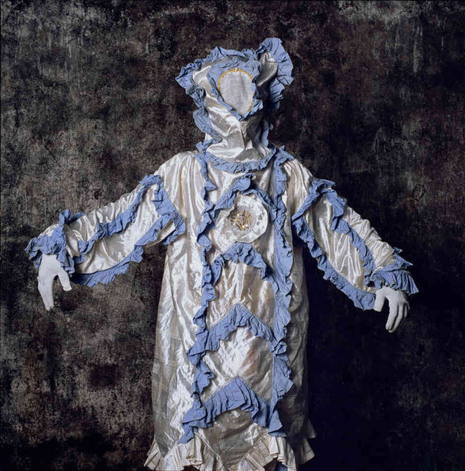 "Frills and ruffles lend a feminine air to this dancing joker, called a jollay, in a Fullahtown parade [in Sierra Leone]. Despite the girlish garb, the actor is a man. Like Greek theater, African masquerades reflect male-dominated societies. Women are often excluded because masks are said to link the wearer to a dangerous spirit world."