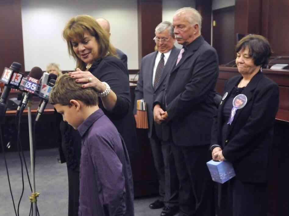 Corey with Samuel Thompson, 9, after a hearing in February for the man convicted of killing Samuel's brother.