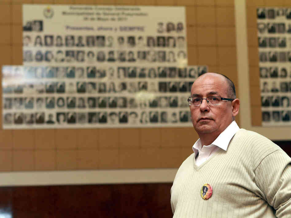 Human rights activist Carlos Diaz stands in Mar del Plata City Hall, where a wall displays portraits of the victims of a 1970s-era military dictatorship in Argentina.