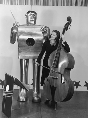 Musician Lois Kendall plays the bass while the robot Elektro Musician Lois Kendall plays the bass while the robot Elektro