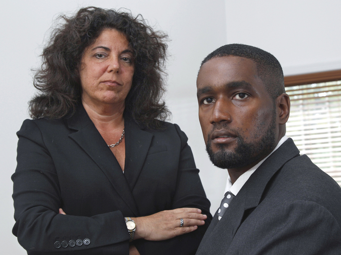 In this Oct. 11, 2011, photo, Albert Florence sits at his home in Bordentown, N.J., with his attorney, Susan Chana Lask. Florence sued after being strip-searched in 2005 when he was arrested because of a computer error.