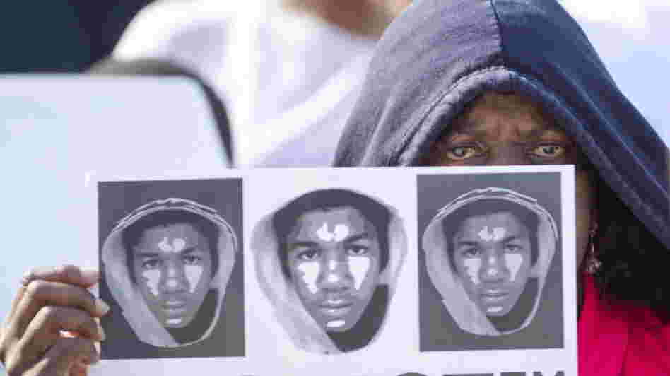 At a rally in Miami on Sunday, Arleen Poitier held a sign with images of Trayvon Martin. 
