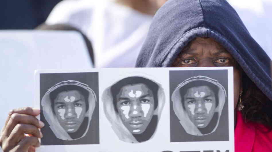 At a rally in Miami on Sunday, Arleen Poitier held a sign with images of Trayvon Martin. 